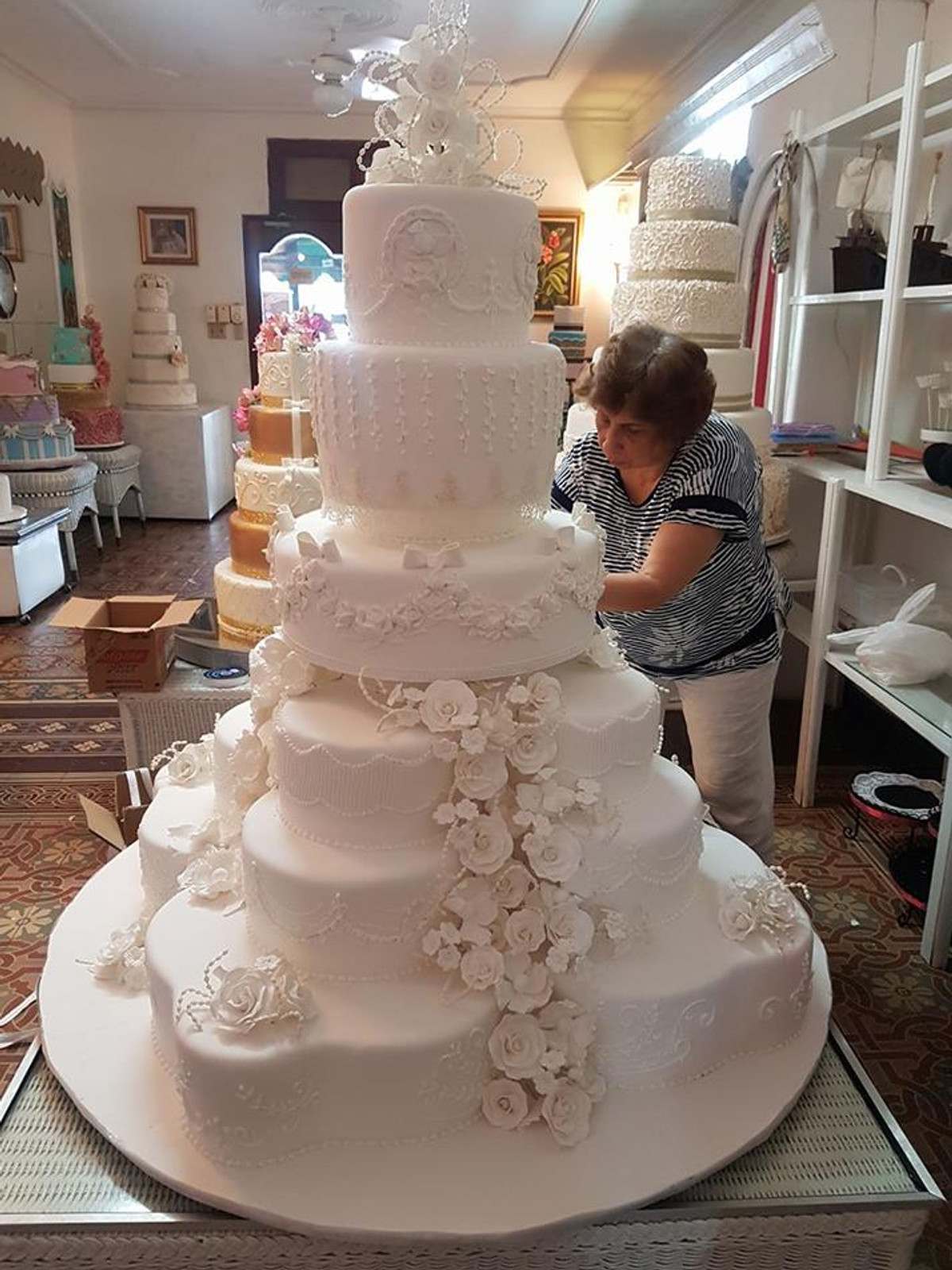 Miriam Gautreaux decorando un pastel de boda de varios niveles